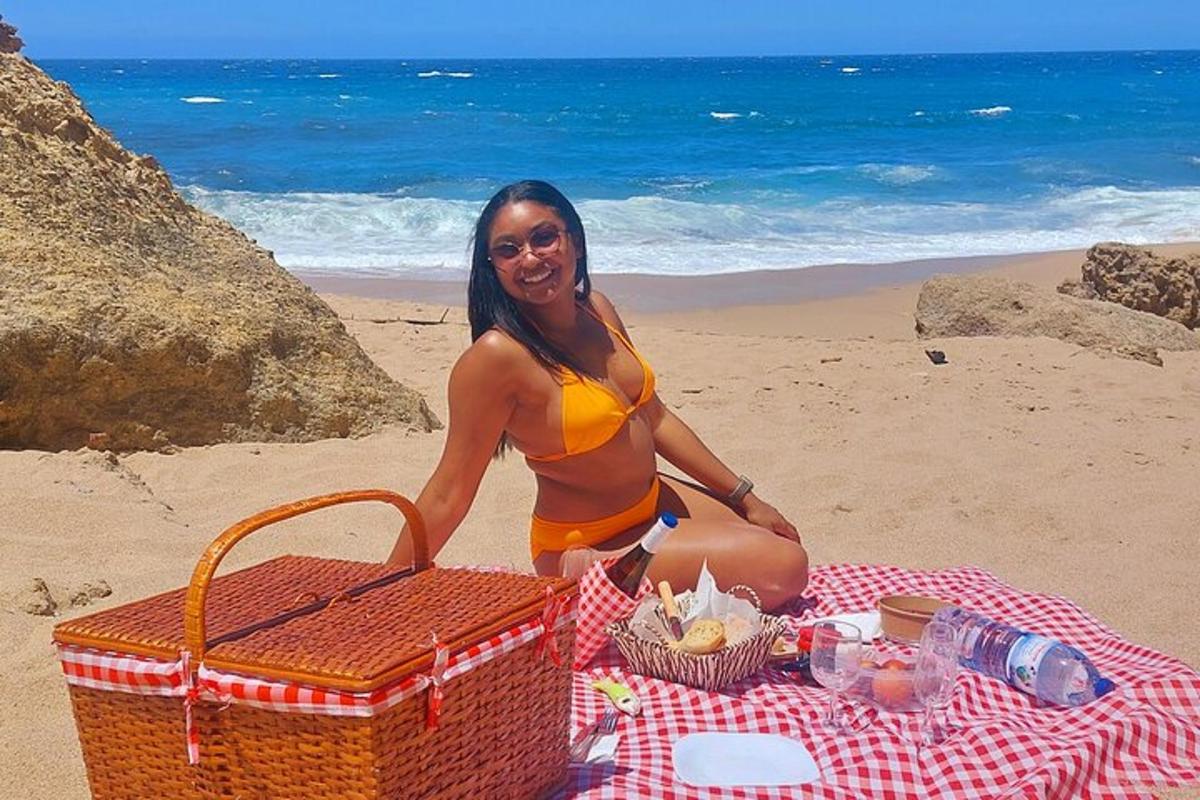 uma mulher sentada em uma toalha de piquenique na praia