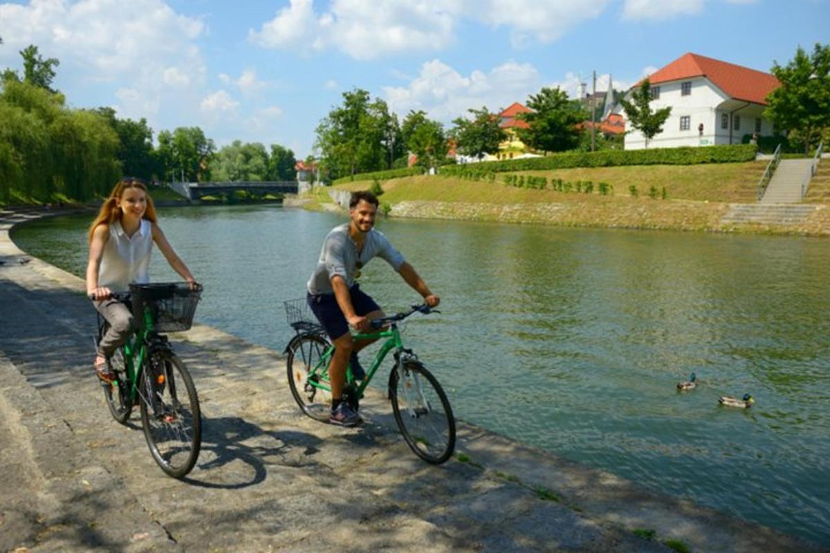 moški in ženska kolesarita ob reki