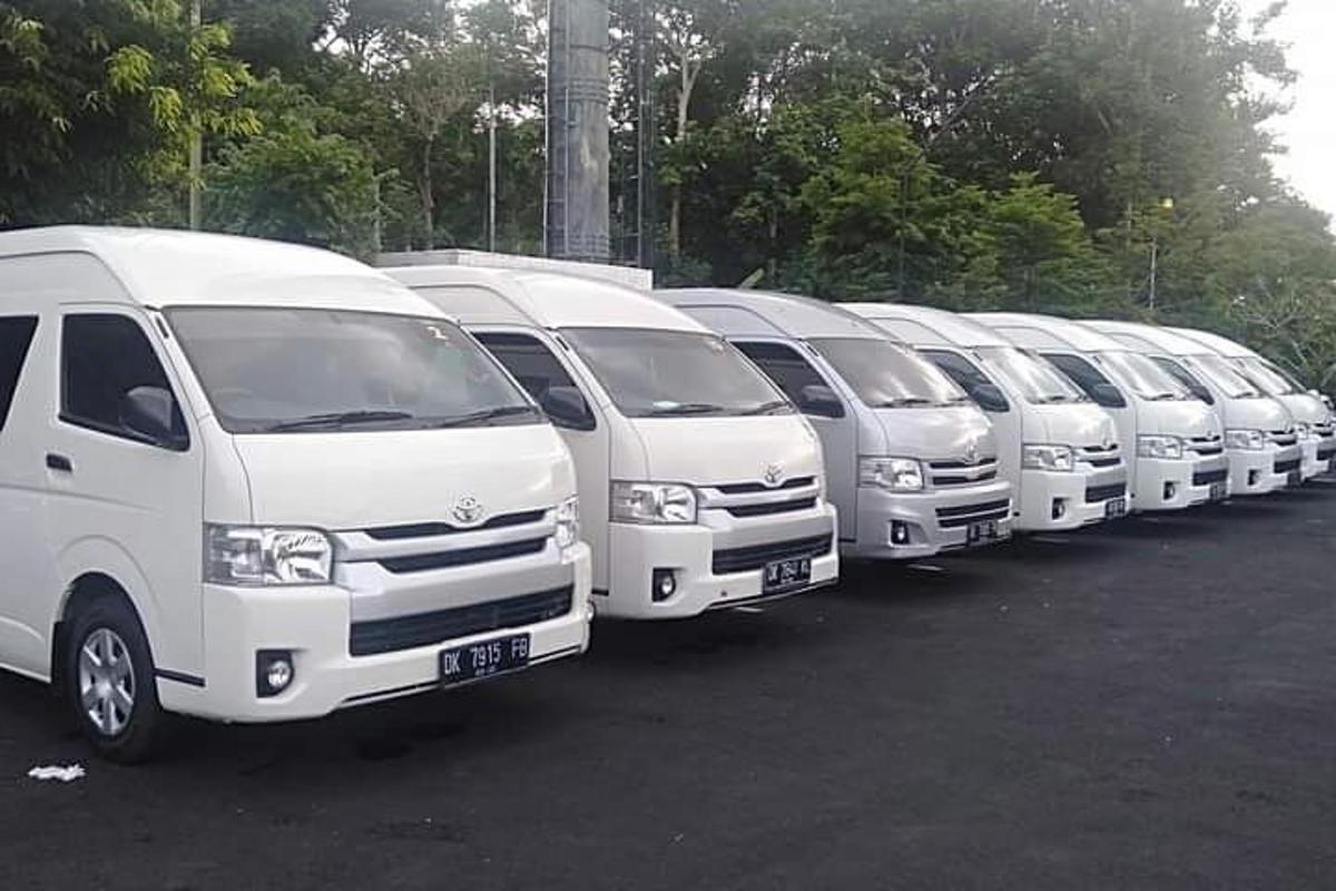 bir otoparkta park edilmiş bir sıra beyaz minibüs