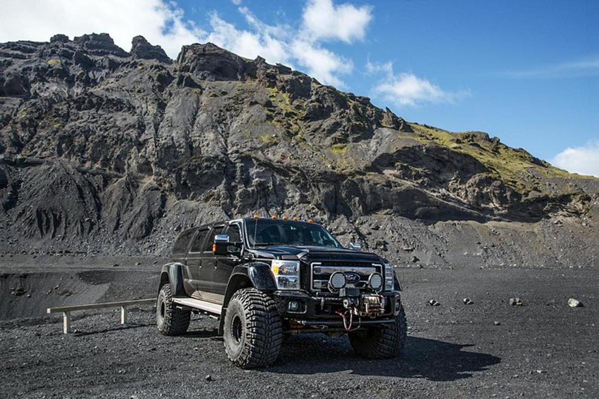 un camion nero parcheggiato davanti a una montagna