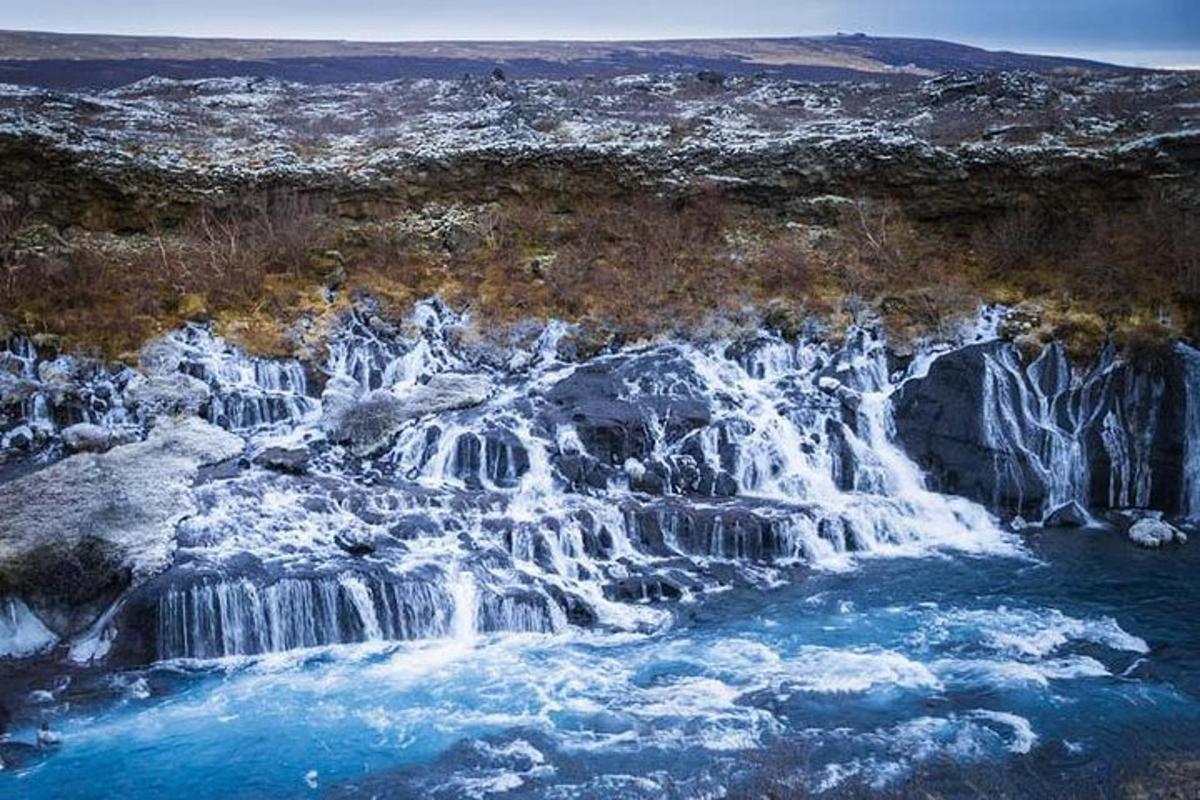 Loftmynd af fossi með bláu vatni