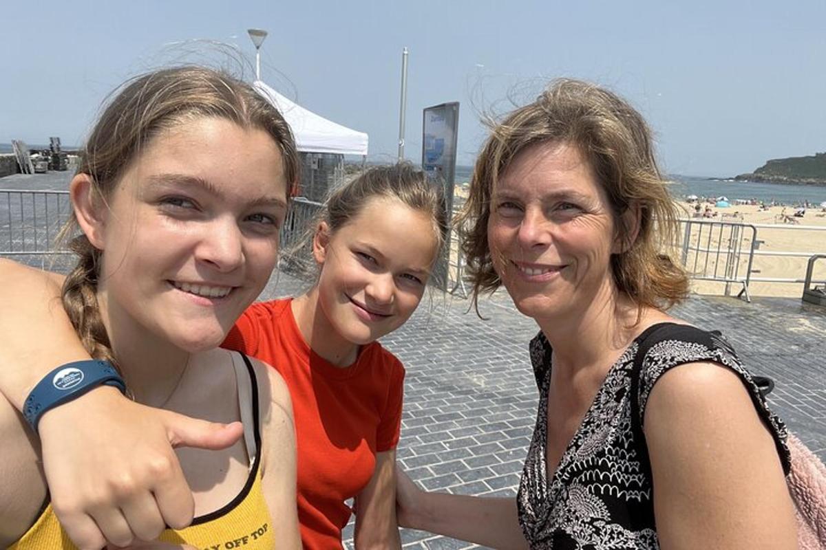 two women and a girl posing for a picture at the beach