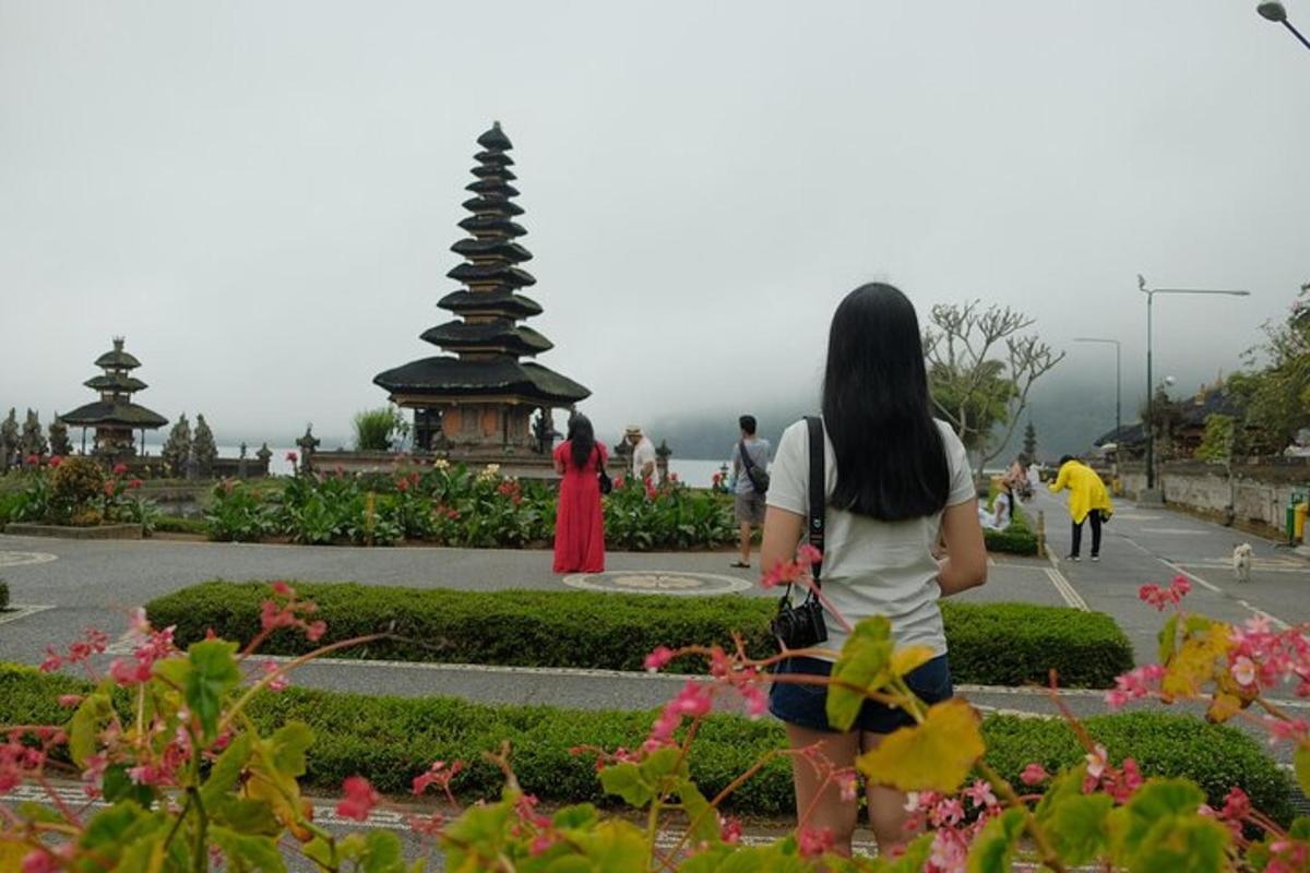 a woman is looking at a statue in a park