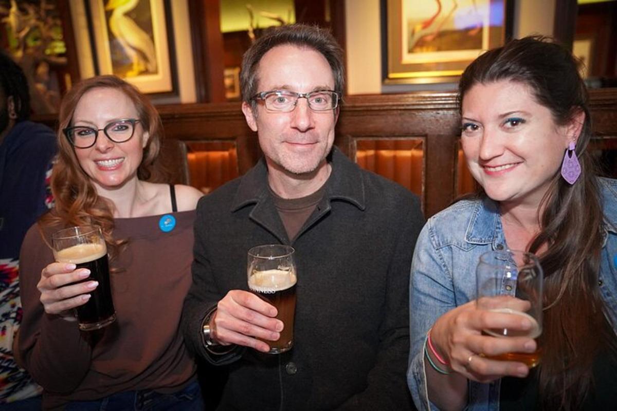 een man en twee vrouwen die glazen bier vasthouden