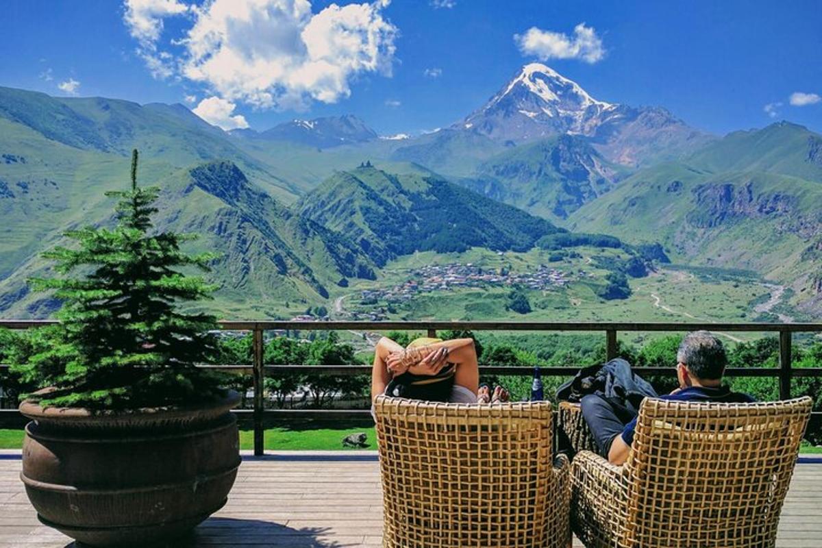 duas pessoas sentadas em cadeiras olhando para uma vista da montanha
