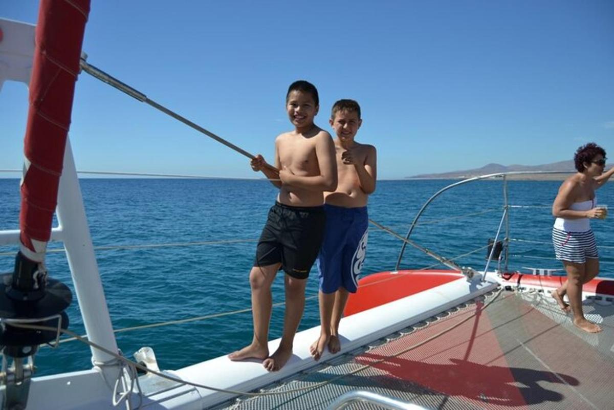 Dos niños de pie en la proa de un velero