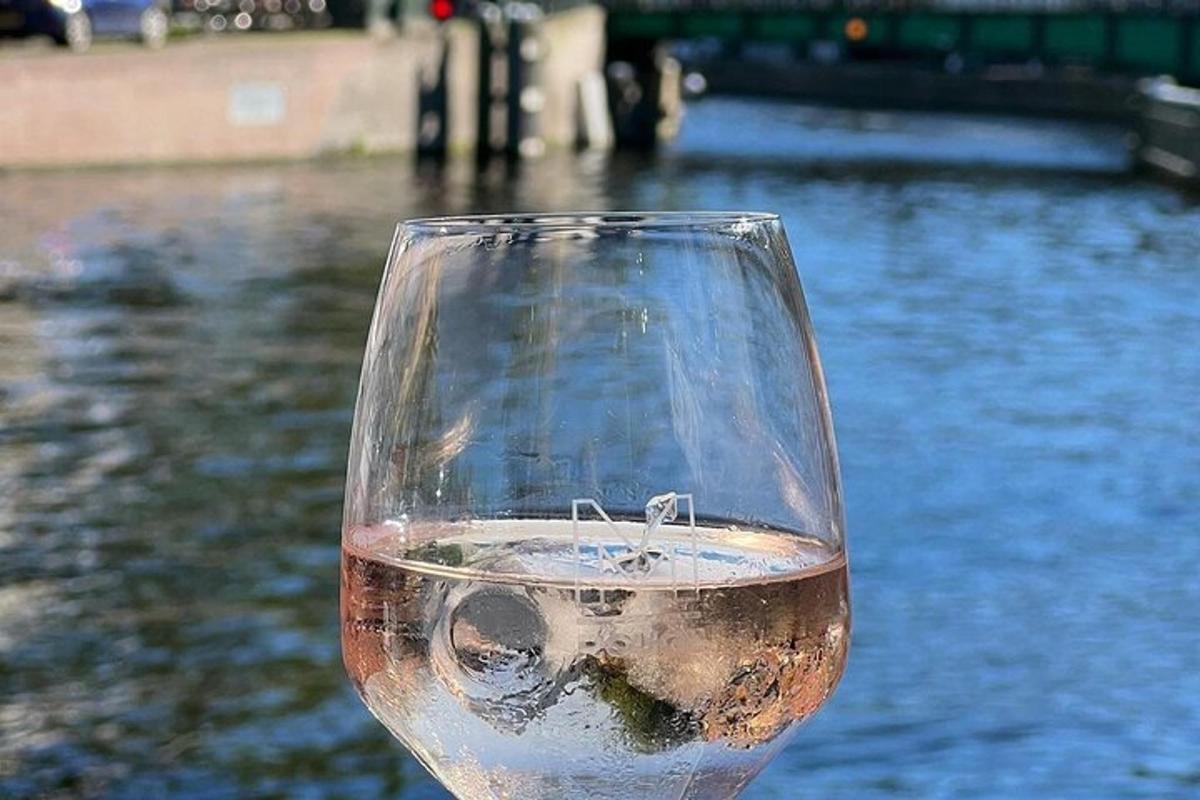 a glass of wine sitting next to a body of water