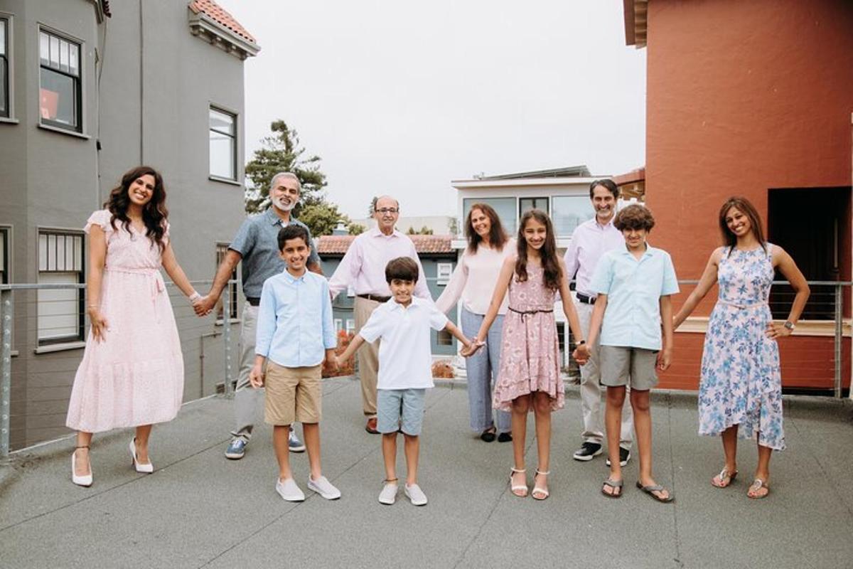o familie numeroasă care pozează pentru o fotografie pe trotuar