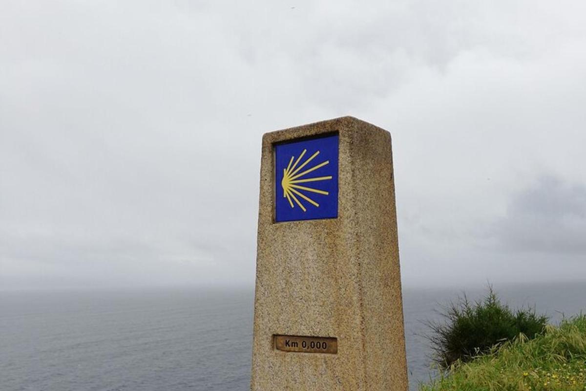 a pillar with a sign on it next to the ocean