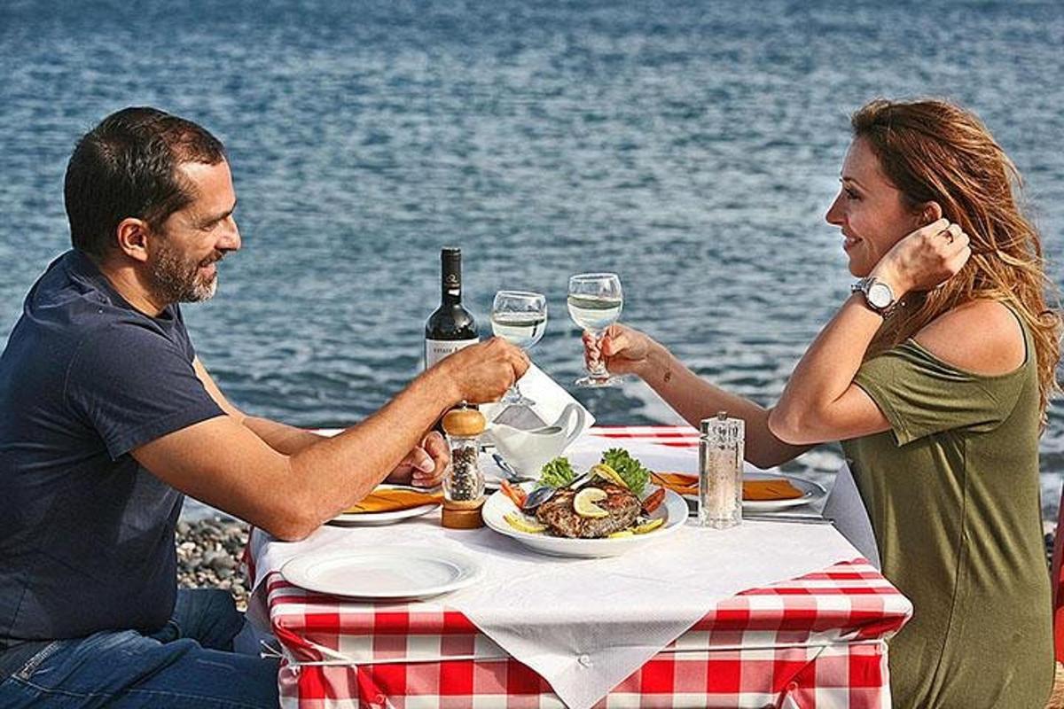 moški in ženska sedita za mizo s krožnikom hrane