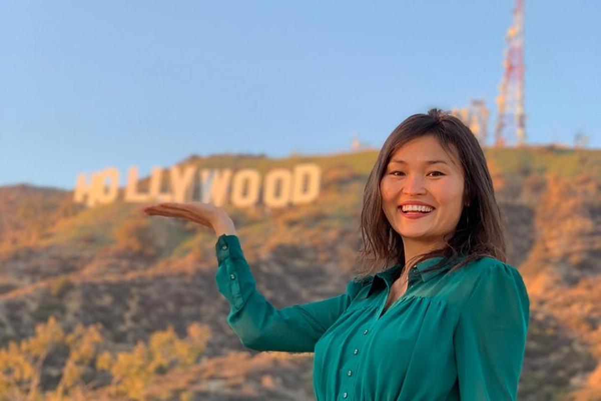 eine Frau steht vor dem Hollywood-Schild