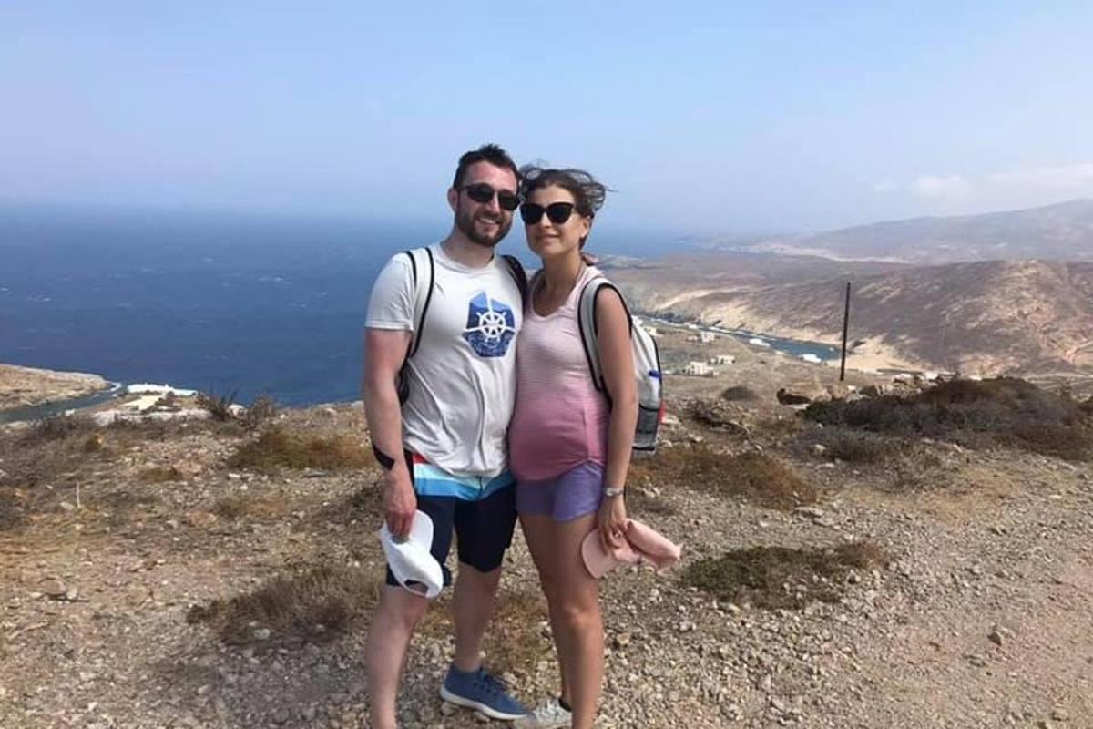 un uomo e una donna in piedi sulla cima di una montagna