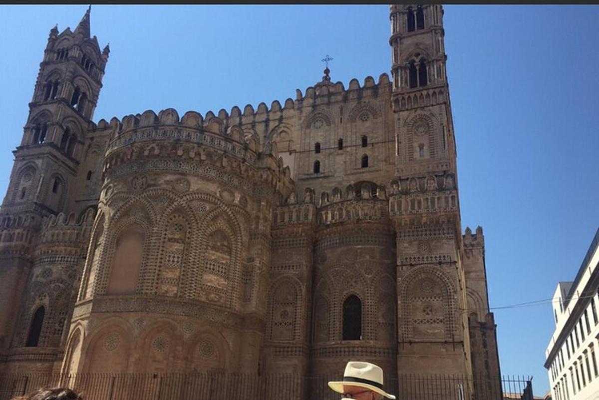 a man in a hat standing in front of a building