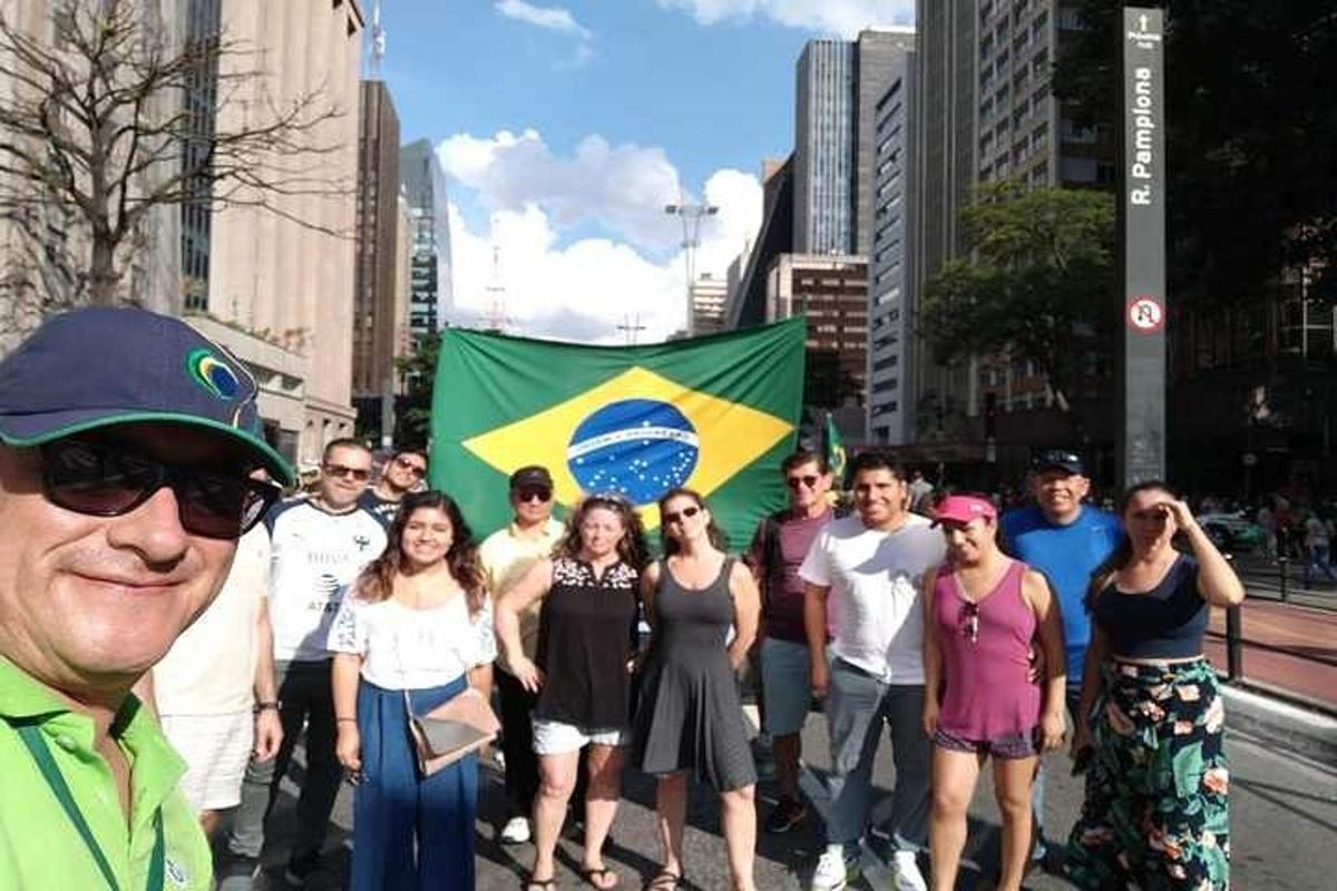 um grupo de pessoas paradas na rua com uma bandeira