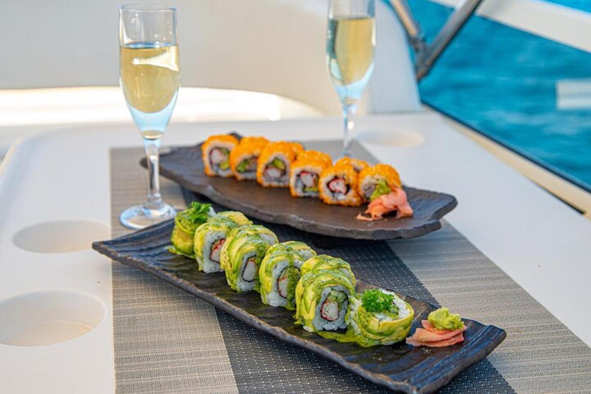 due piatti di sushi su un tavolo con bicchieri di vino