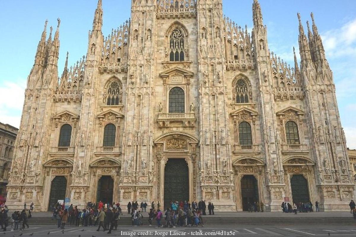 una grande cattedrale con persone in piedi davanti ad essa