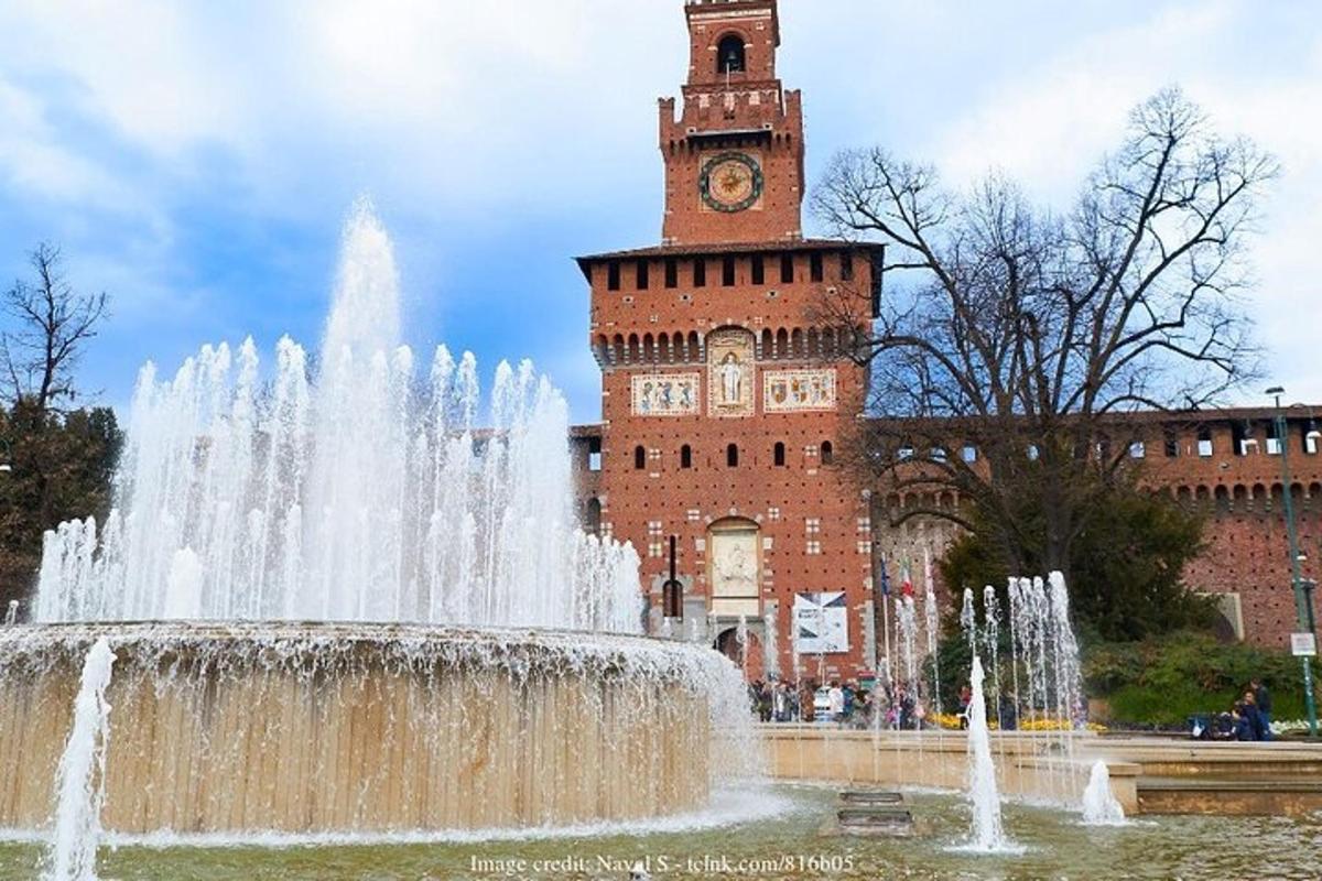 una fontana d'acqua di fronte a un edificio con una torre dell'orologio