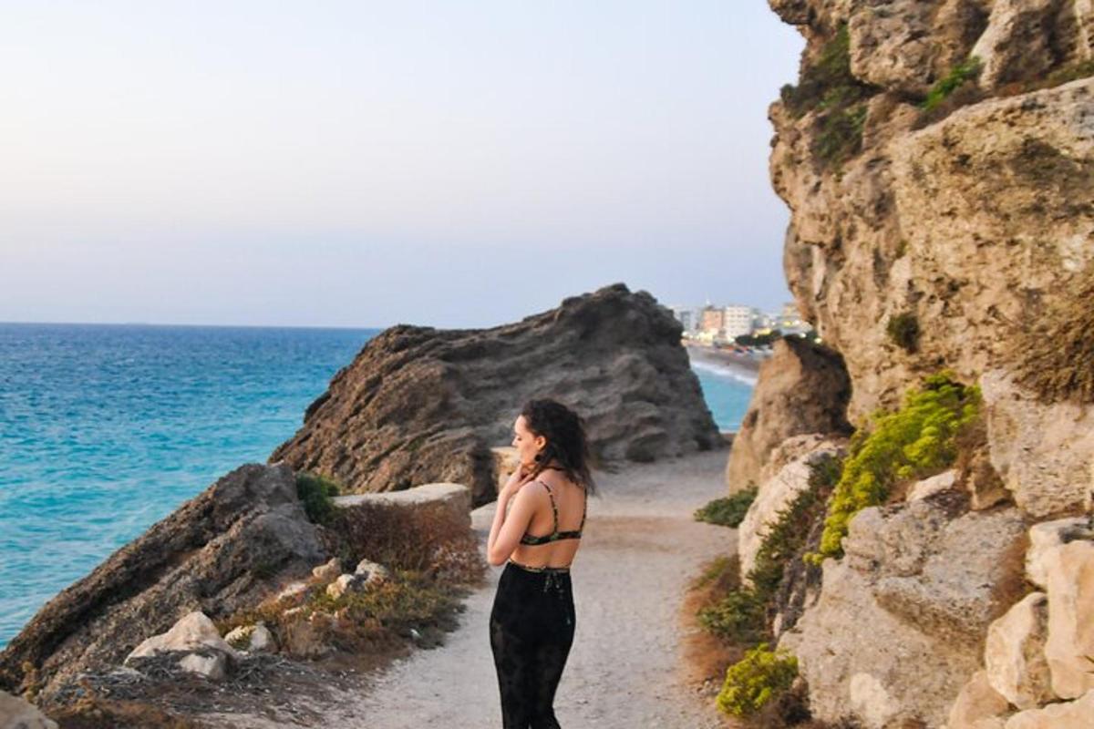 una donna in piedi su un sentiero vicino all'oceano