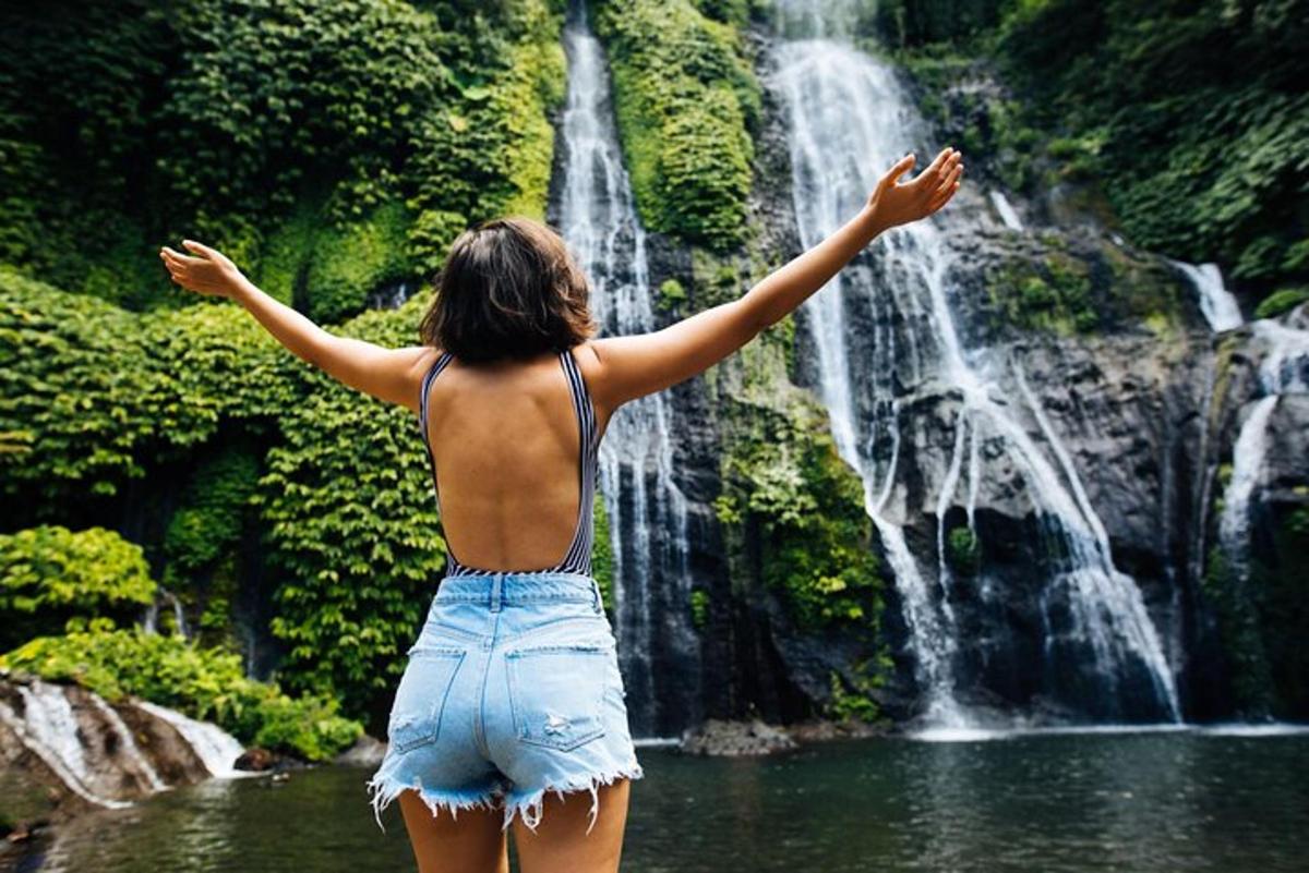 a woman standing in front of a waterfall