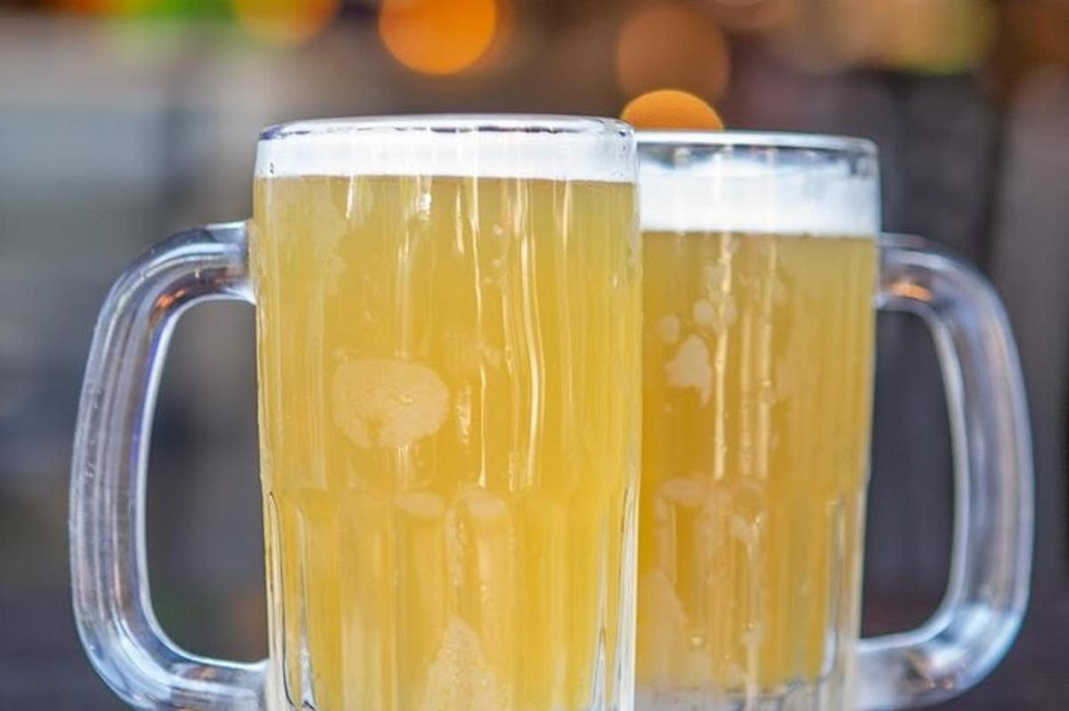 two glass mugs of beer sitting next to each other