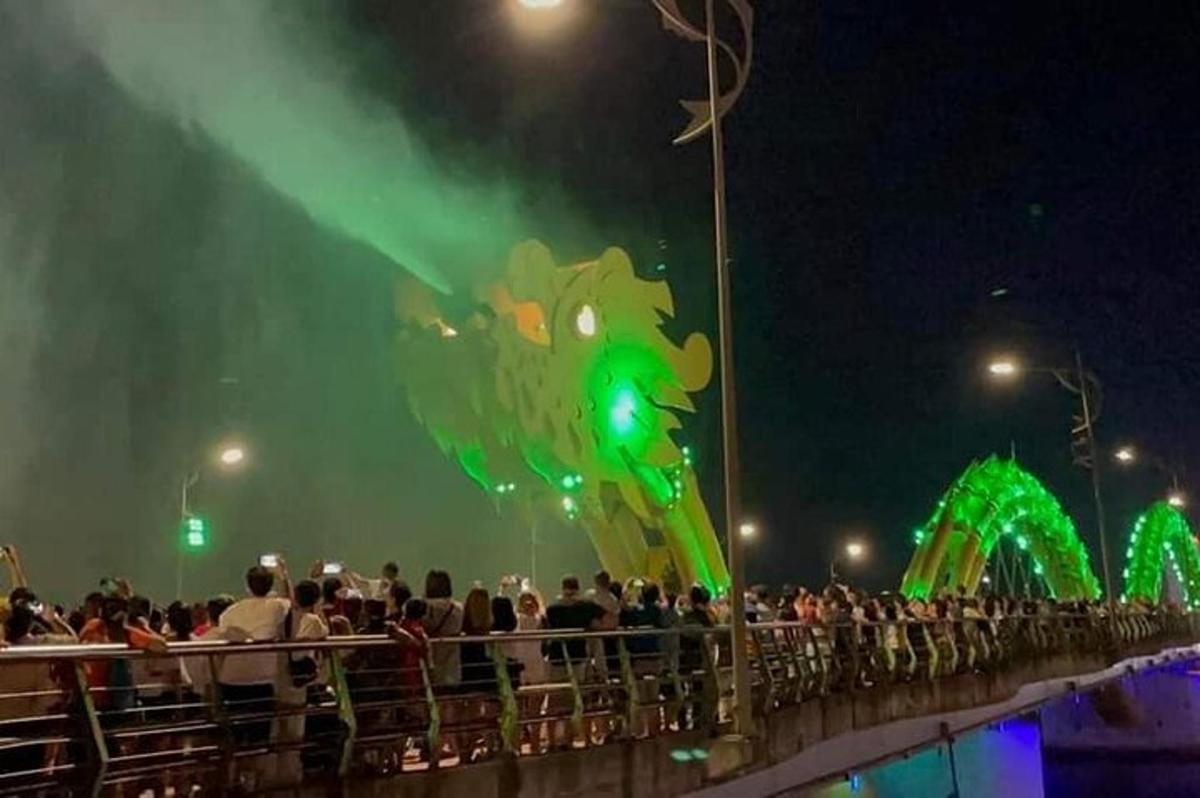 a large crowd of people watching a green dragon parade