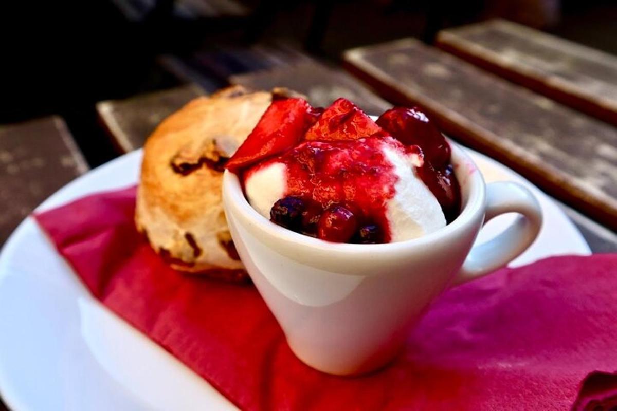 a white cup of dessert with fruit on a plate