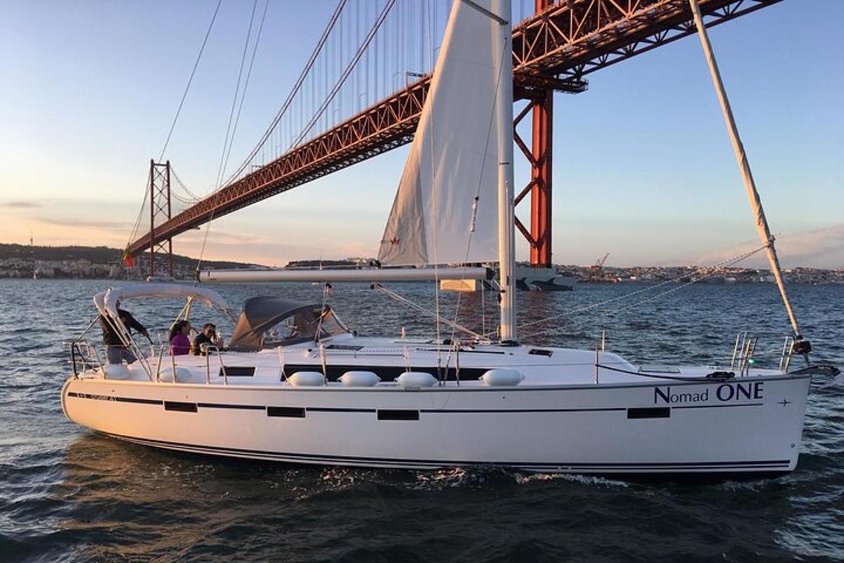 una barca a vela in acqua accanto a un ponte