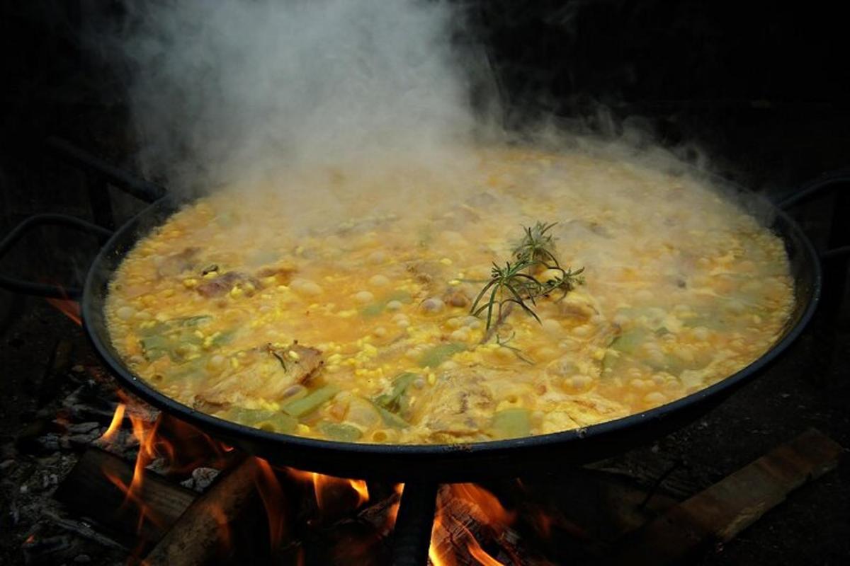 una grande pentola di cibo che cuoce sul fuoco