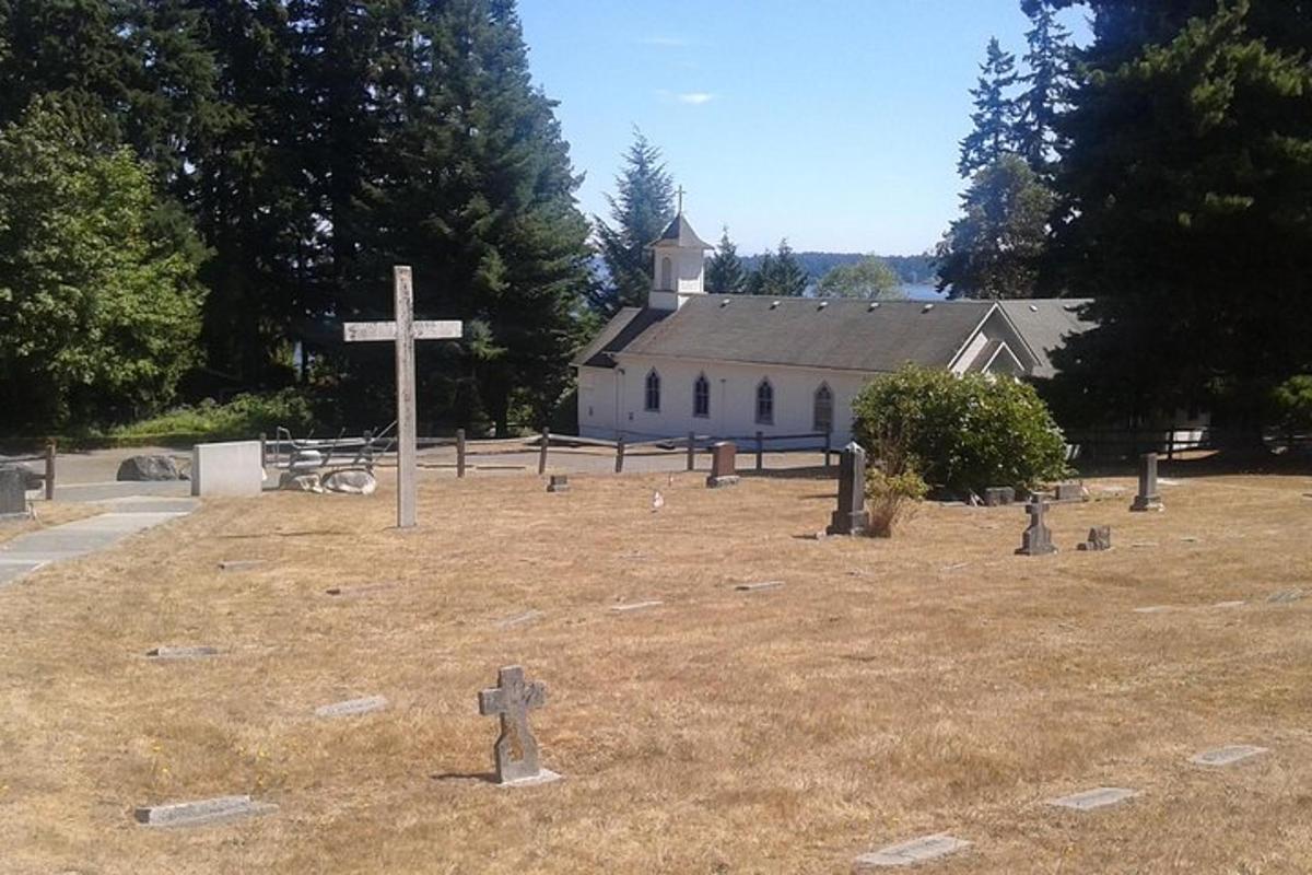 egy kereszt egy mező közepén egy templommal
