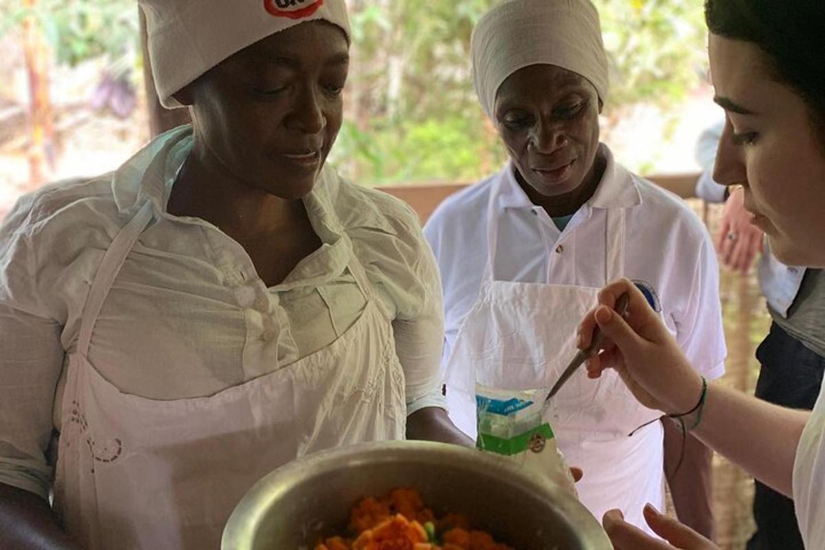 a group of women standing around a bowl of food