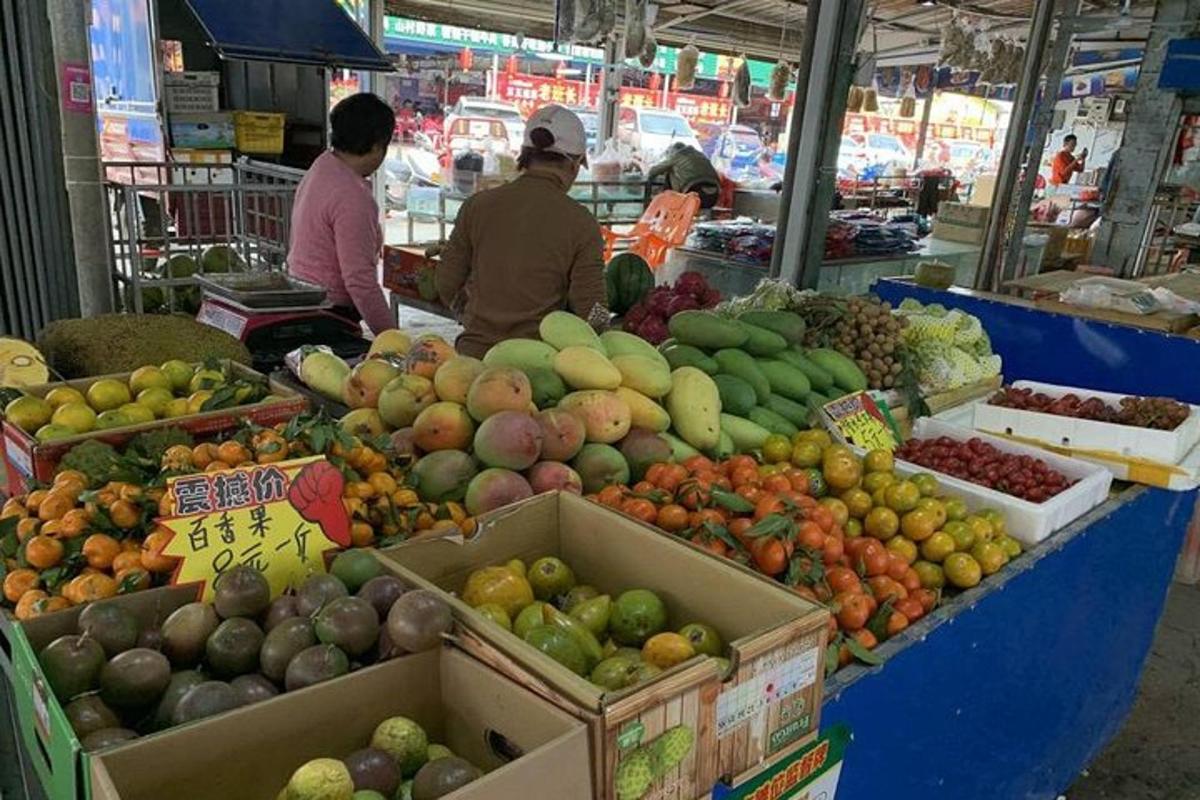 two people in a market with fruits and vegetables