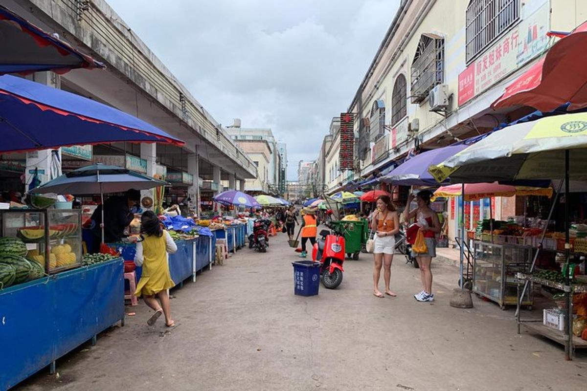 a group of people standing in a market with umbrellas