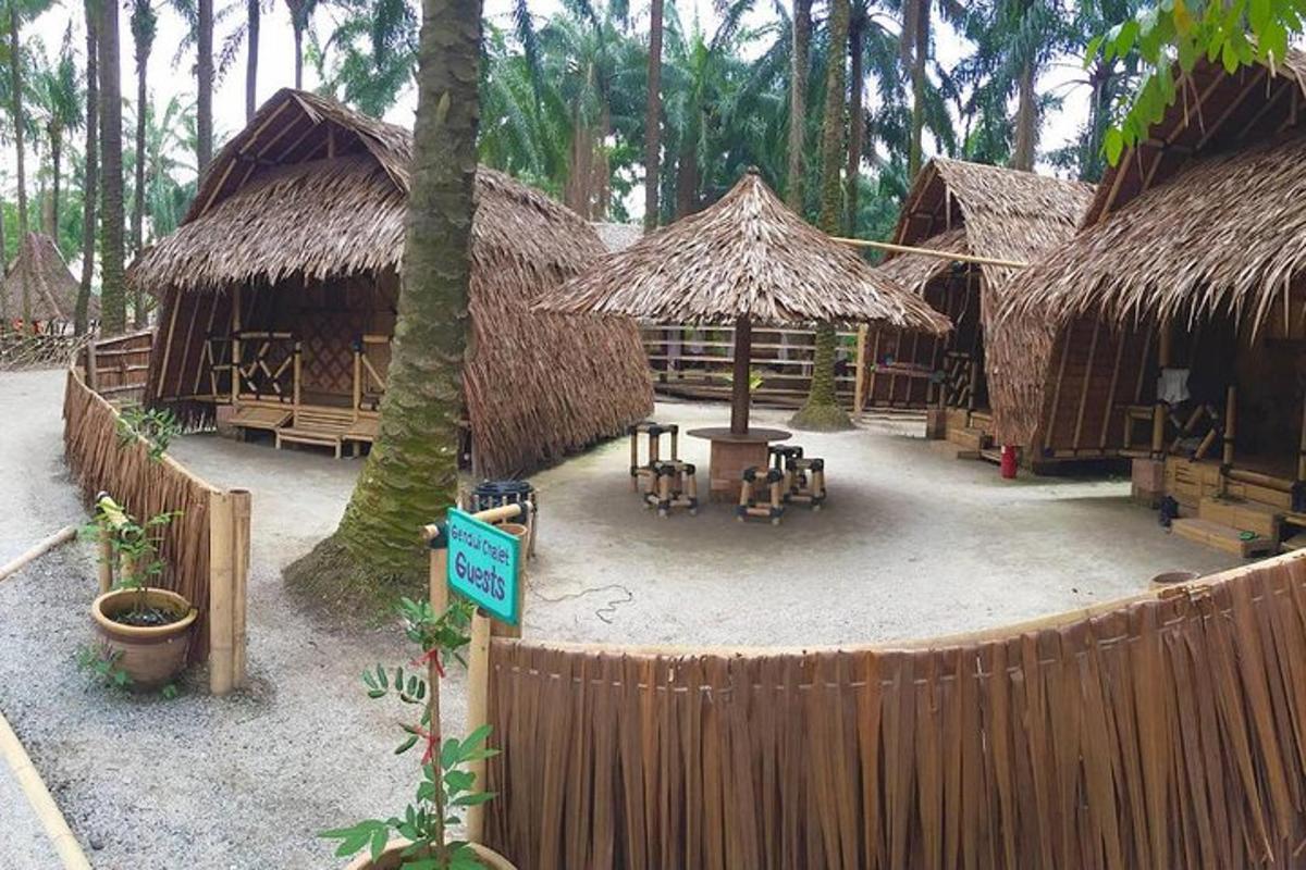 a group of huts with tables and chairs and a fence