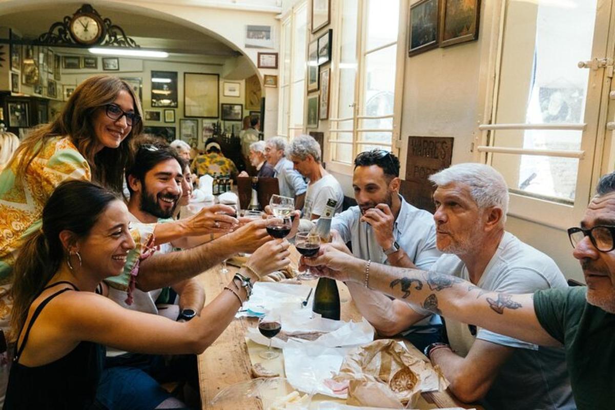Un grupo de personas sentadas alrededor de una mesa bebiendo vino.
