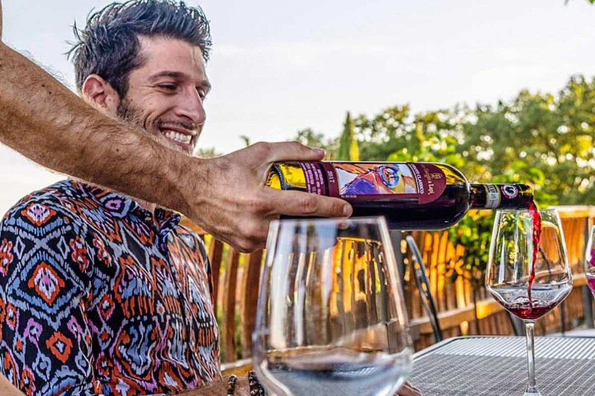 a man pouring a bottle of wine into two glasses