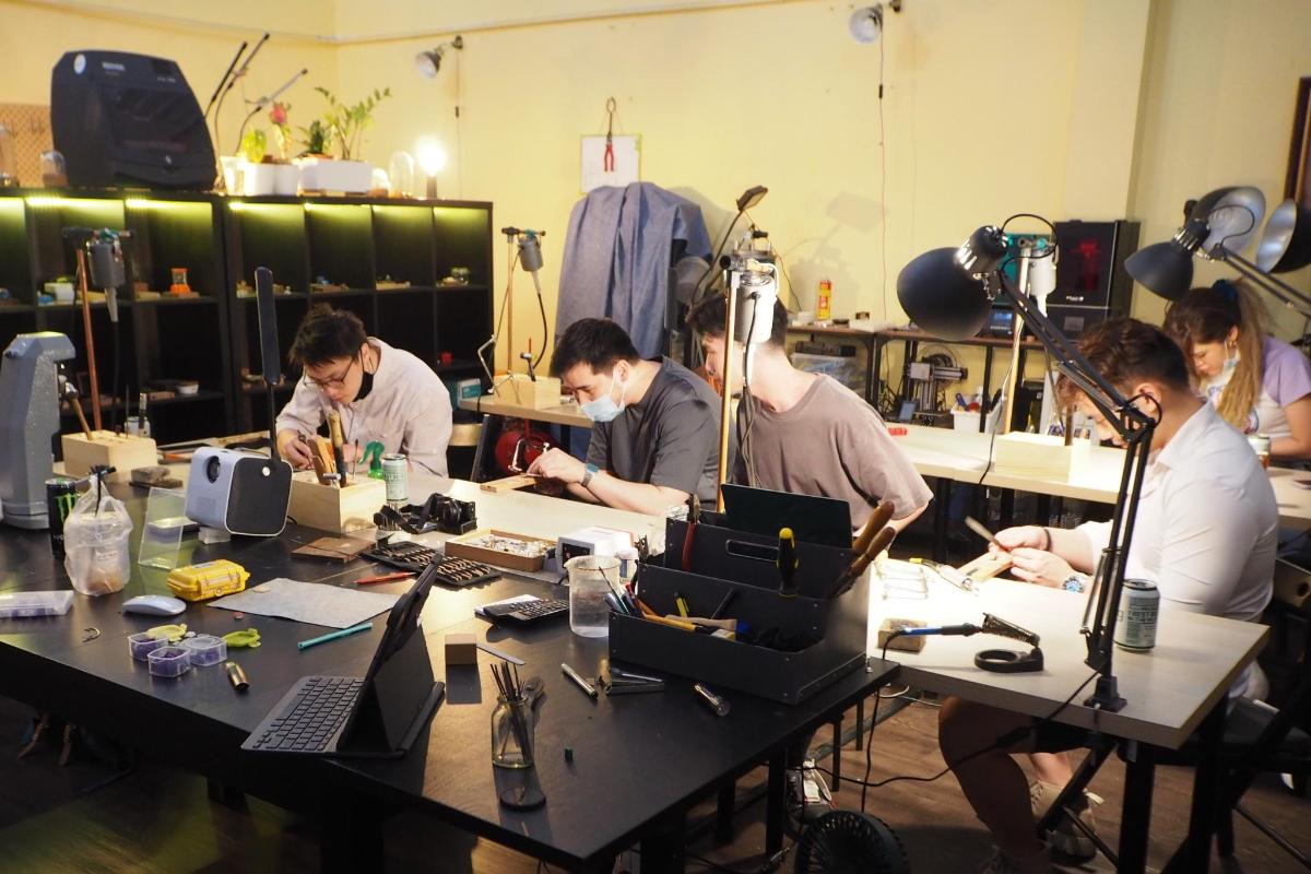 a group of men working at a table in a workshop