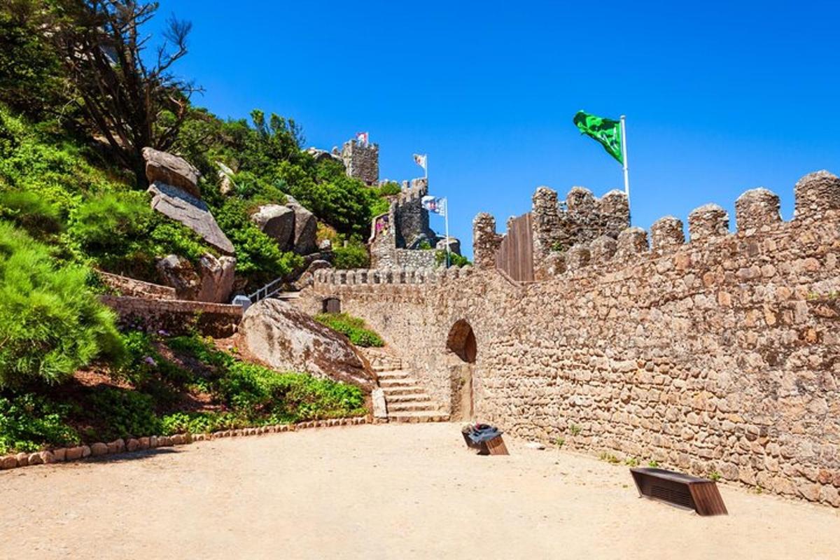 a stone castle with stairs and a flag on a hill