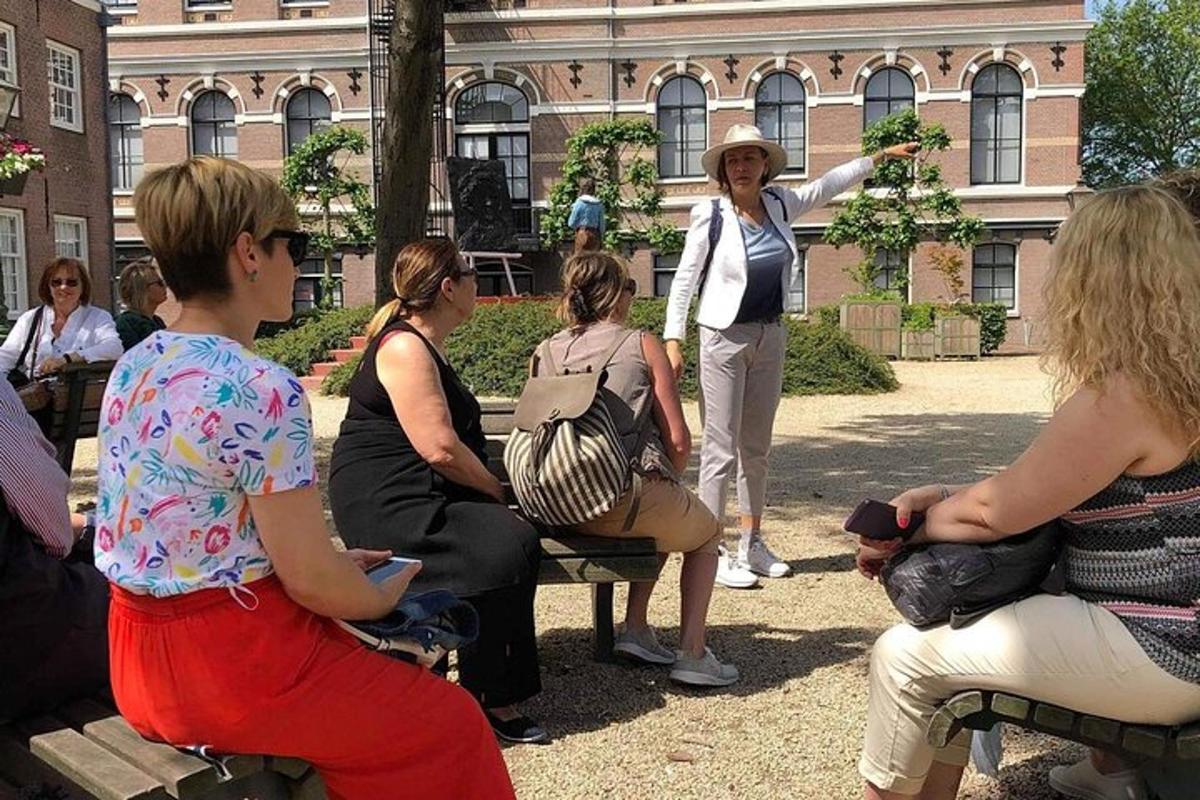 skupina lidí sedících na lavičkách před budovou