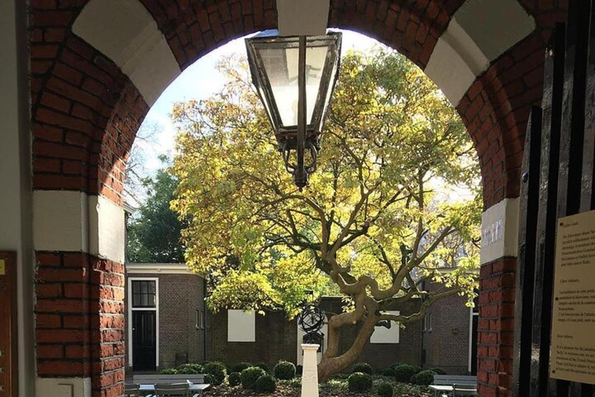 ein Torbogen mit einer Lampe und einem Baum vor einem Gebäude
