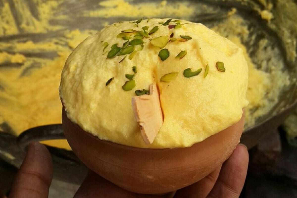 seseorang yang memegang sandwic dengan bawang hijau di atasnya