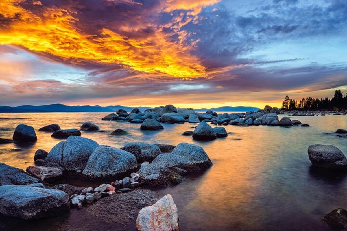 a group of rocks in the water at sunset
