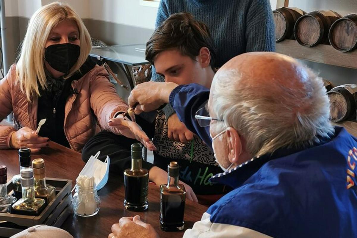 un grup de persones assegudes al voltant d'una taula amb ampolles de vi
