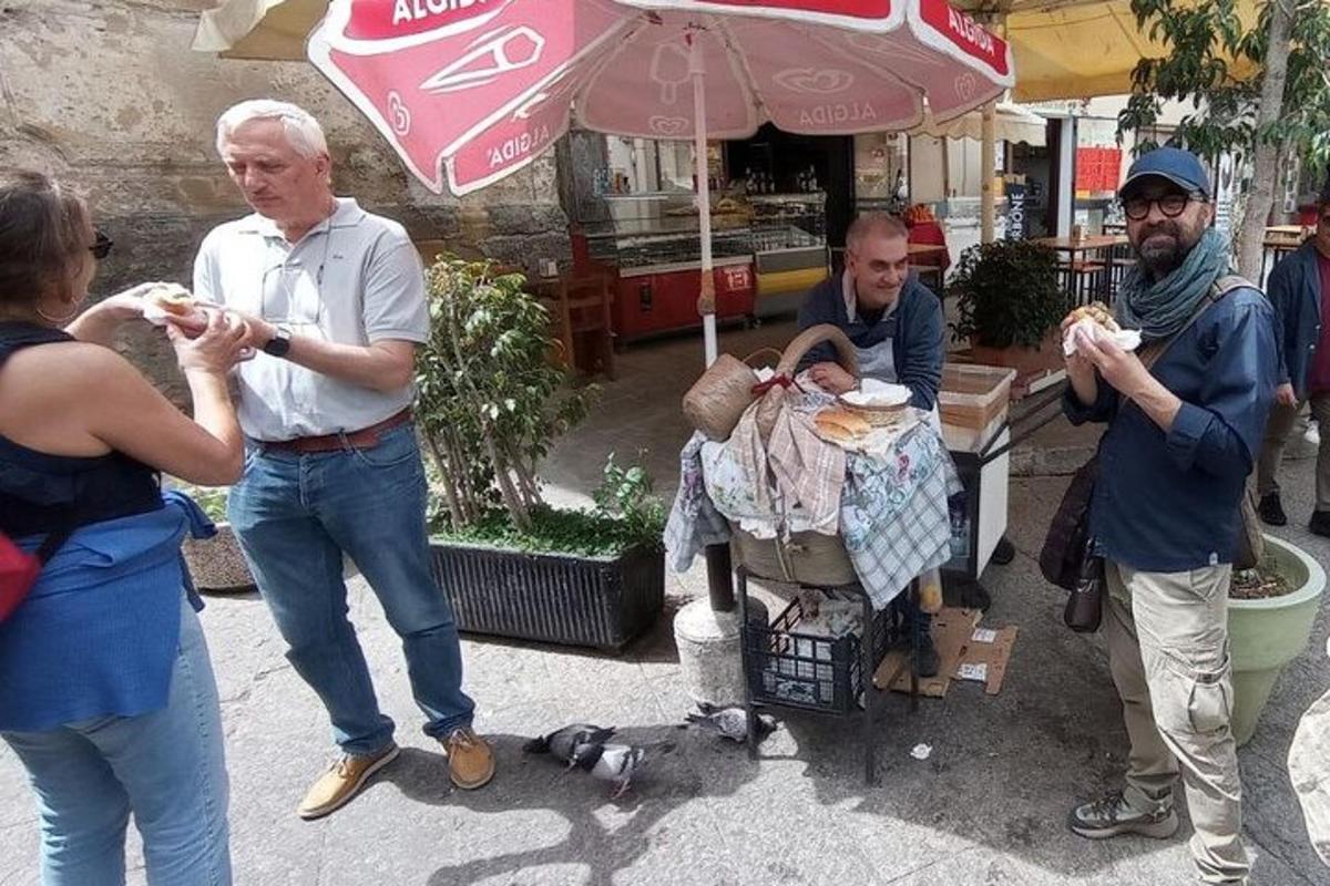 a group of people eating food on the street
