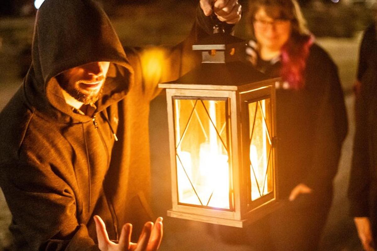 a man in a nun costume holding a lantern