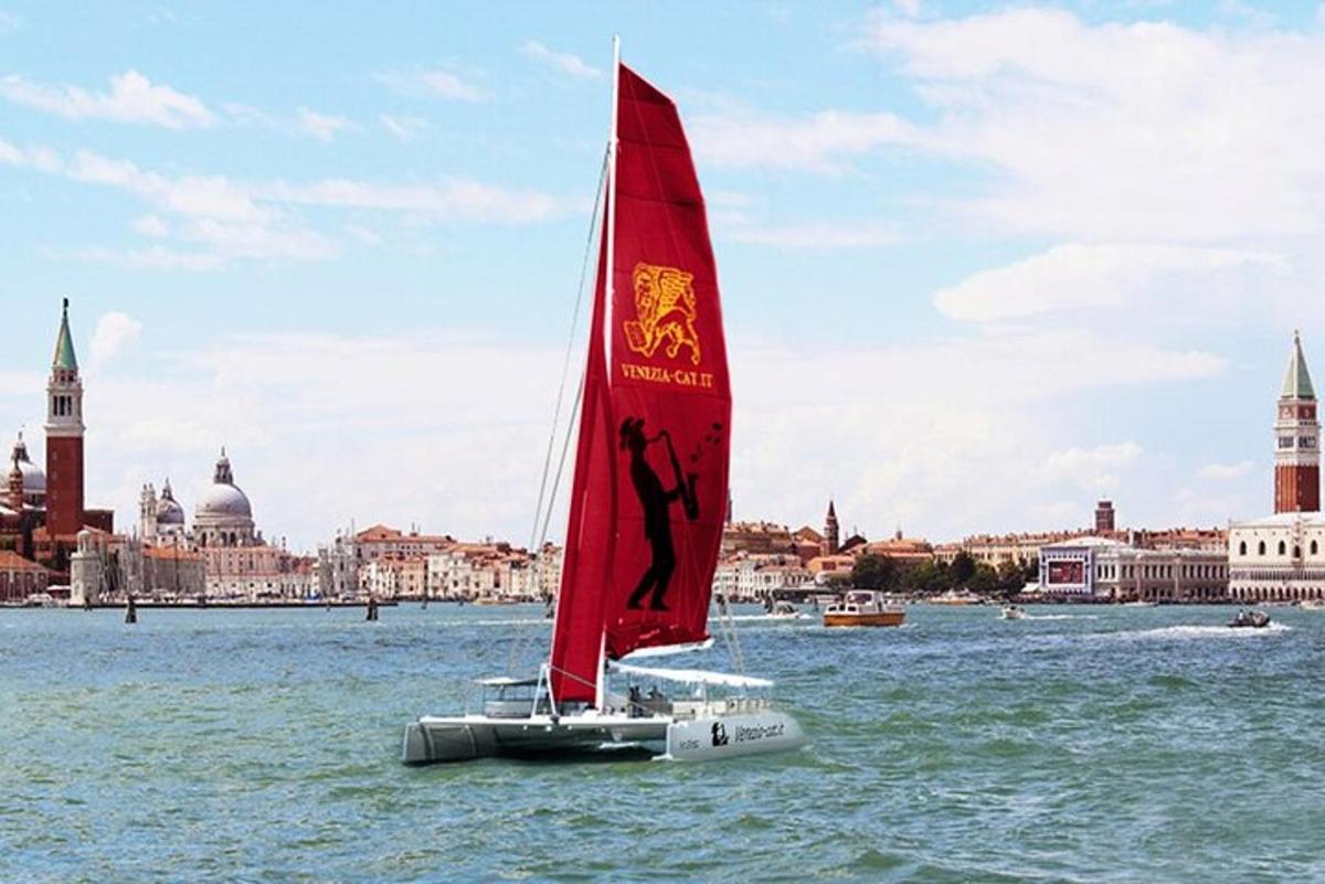 Un velero con una vela roja está en el agua
