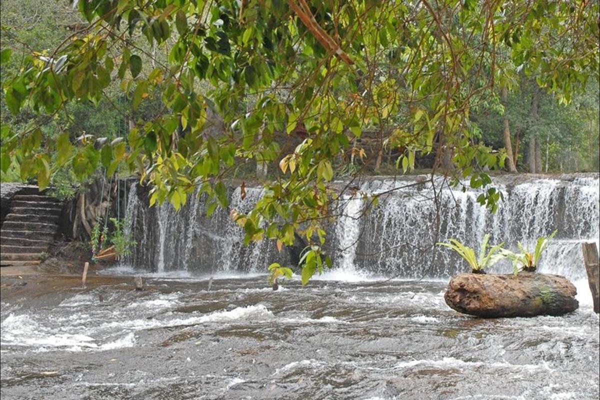 a waterfall with a rock in front of a river