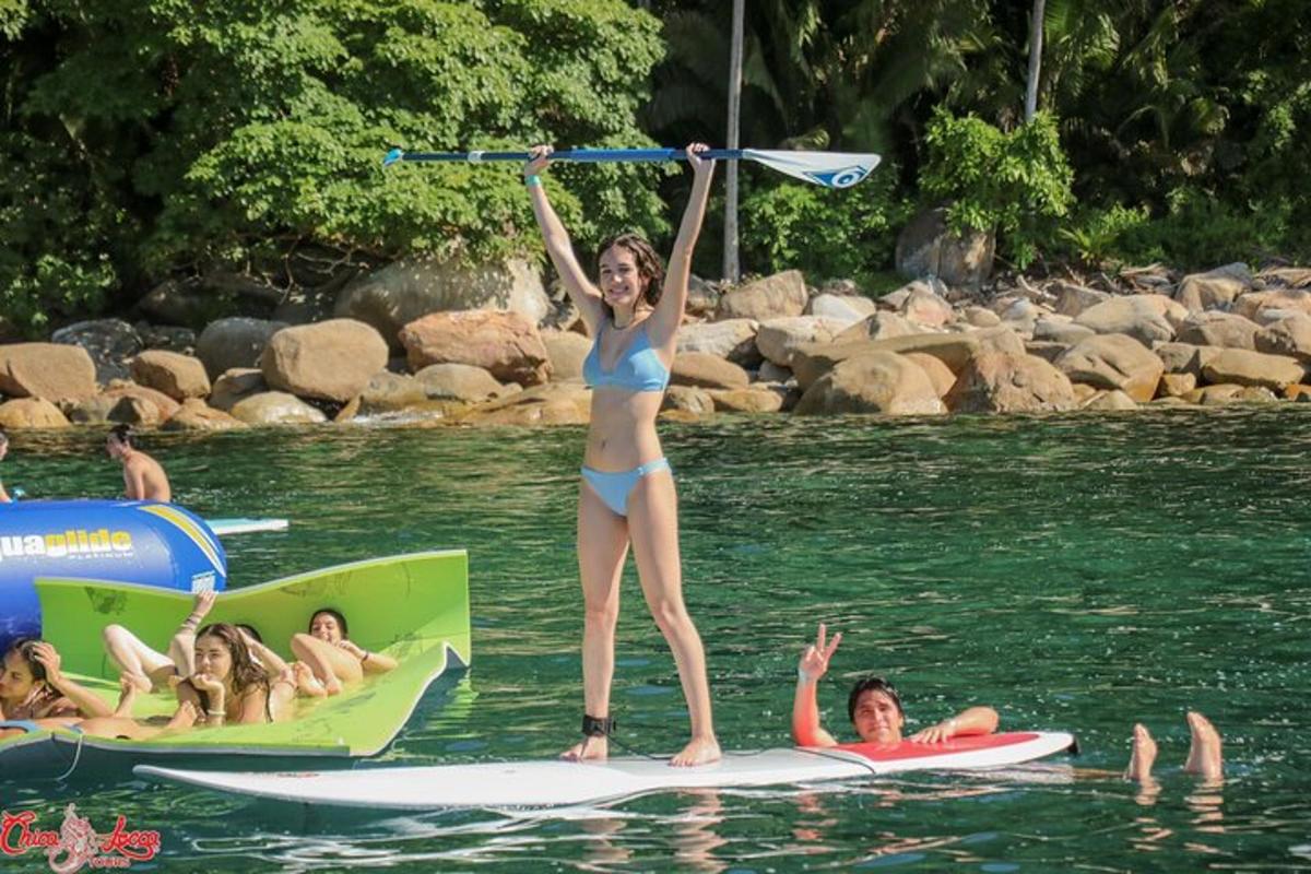 a woman in a bikini standing on surfboards in the water