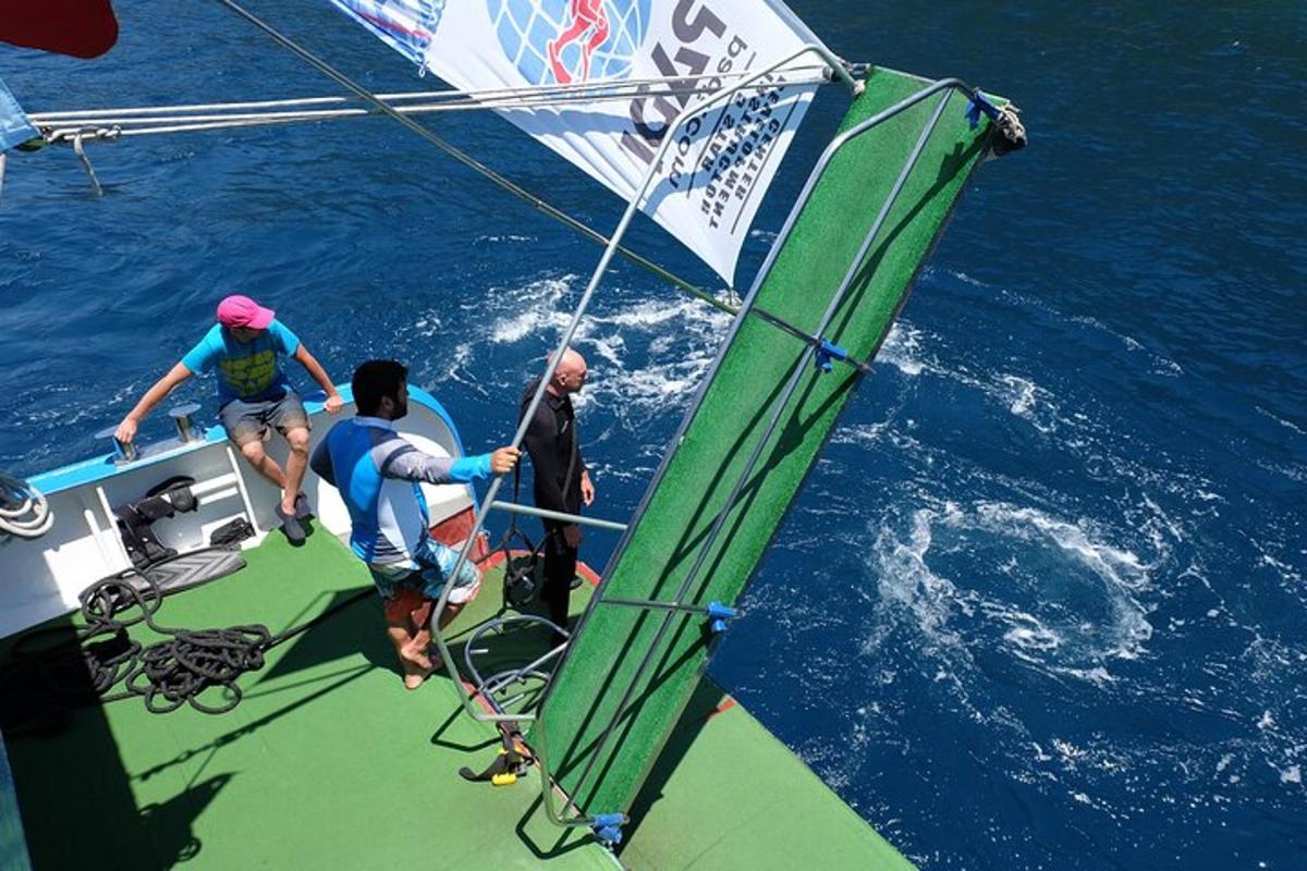 three people on a sail boat in the water