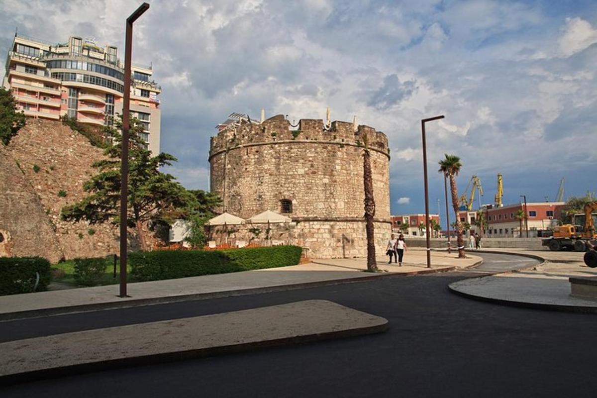 un antic mur de pedra amb un edifici al costat d'un carrer