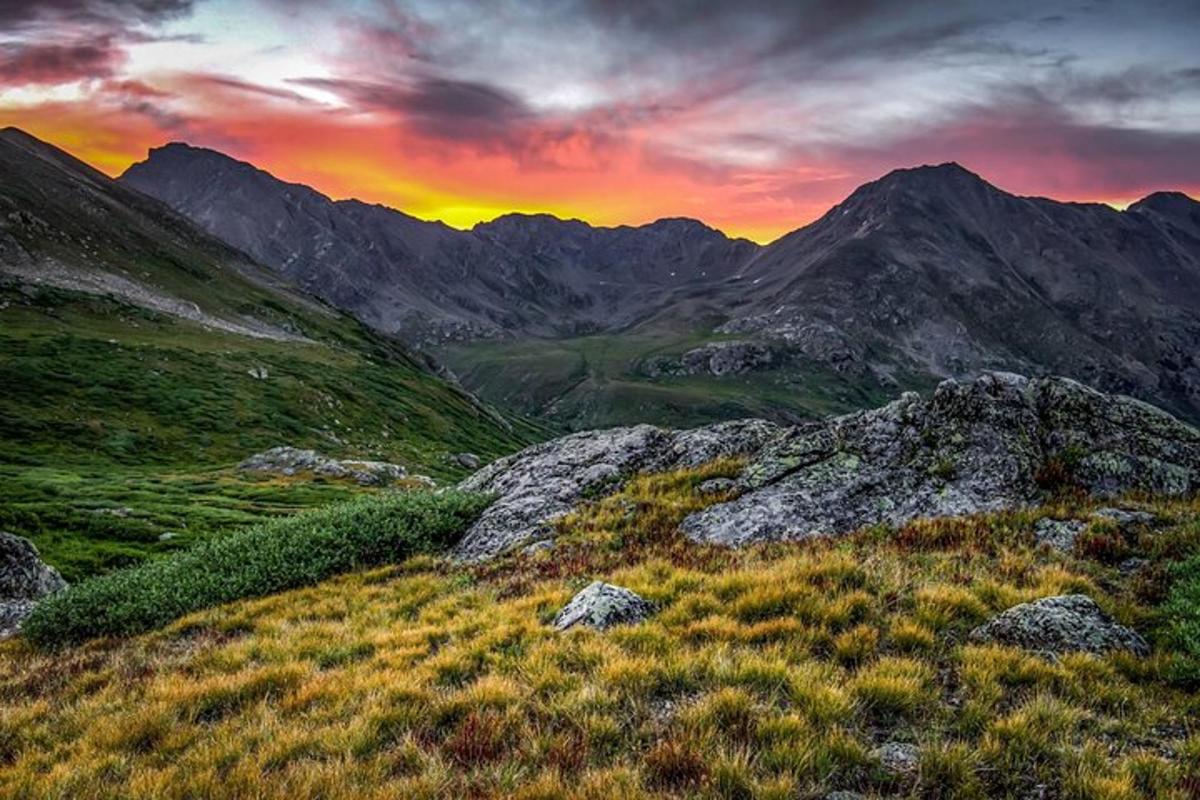 un tramonto su una montagna con le montagne sullo sfondo